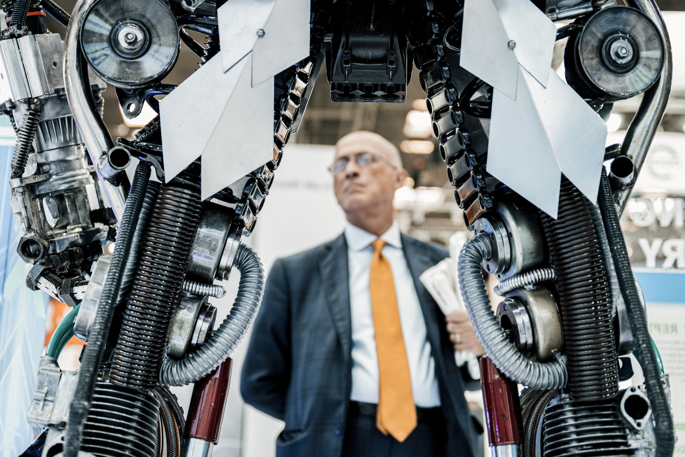 Geschäftsmann auf einer Industriemesse vor einer Maschine