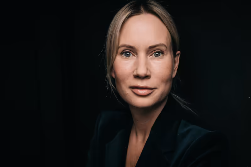 Frau in dunklem Businessblazer, Porträt vor schwarzem Hintergrund, professionelle Kopfschuss