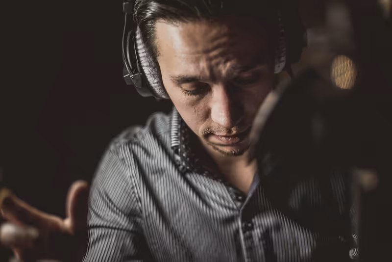 Mann mit Headset konzentriert bei der Arbeit, professionelle Geschäftsporträt vor dunklem Hintergrund