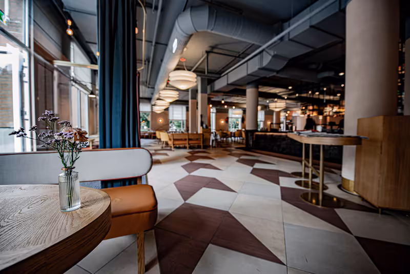 Modernes Businesshotel-Foyer mit geometrischem Bodenmuster, Designermöbeln und eleganter Beleuchtung