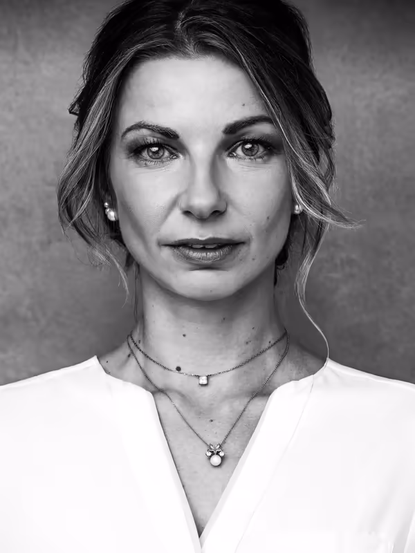 Porträt einer Frau in weißer Bluse, direkter Blick, Schwarz-Weiß-Aufnahme, professionelle Kopfschuss-Fotografie