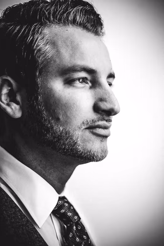 Mann im Businessporträt, Profilansicht, Anzug und Krawatte, schwarzweiß Fotografie, nachdenkliche Ausstrahlung