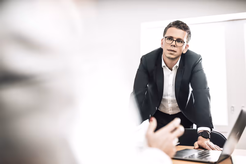 Mann im Anzug bei Geschäftsbesprechung am Laptop, professionelle Unternehmensatmosphäre