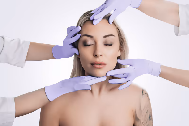 Frau bei dermatologischer Untersuchung, mehrere behandschuhte Hände untersuchen Gesicht und Hals