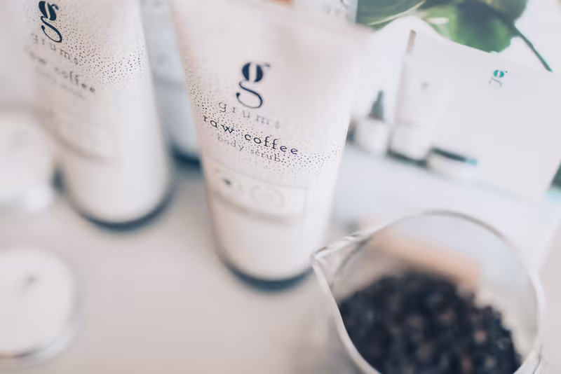 Iced-Coffee-Getränke in beschlagenen Gläsern mit Branding, Kaffeebohnen und Pflanze im modernen Business-Setting