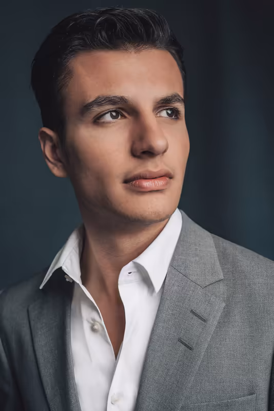 Mann in grauem Sakko und weißem Hemd, professionelles Business-Porträt vor neutralem Hintergrund