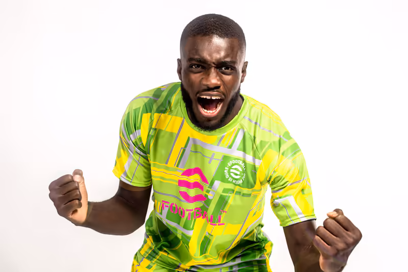 Mann in neongelb-grünem Sportshirt mit jubelnder Geste, energiegeladene Porträtaufnahme vor weißem Hintergrund