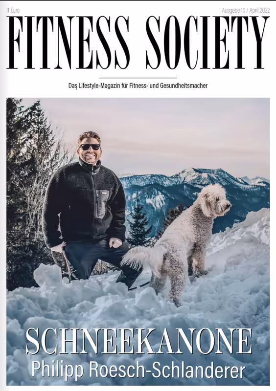 Mann mit Sonnenbrille und Hund im Schnee vor Berglandschaft
